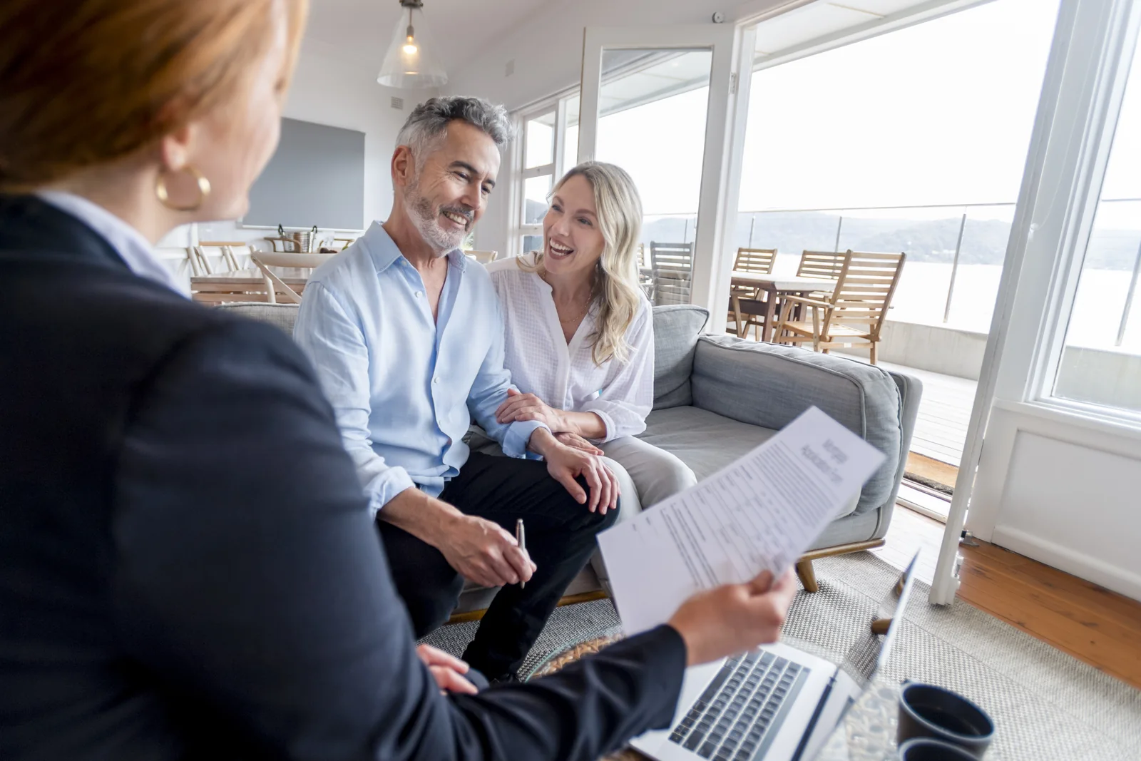 An advisor reviewing tax documents with a couple in their home.