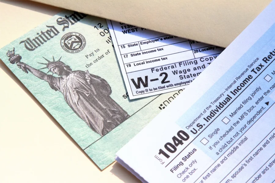 A Form 1040, a W-2, and a U.S. Treasury check on a desk.